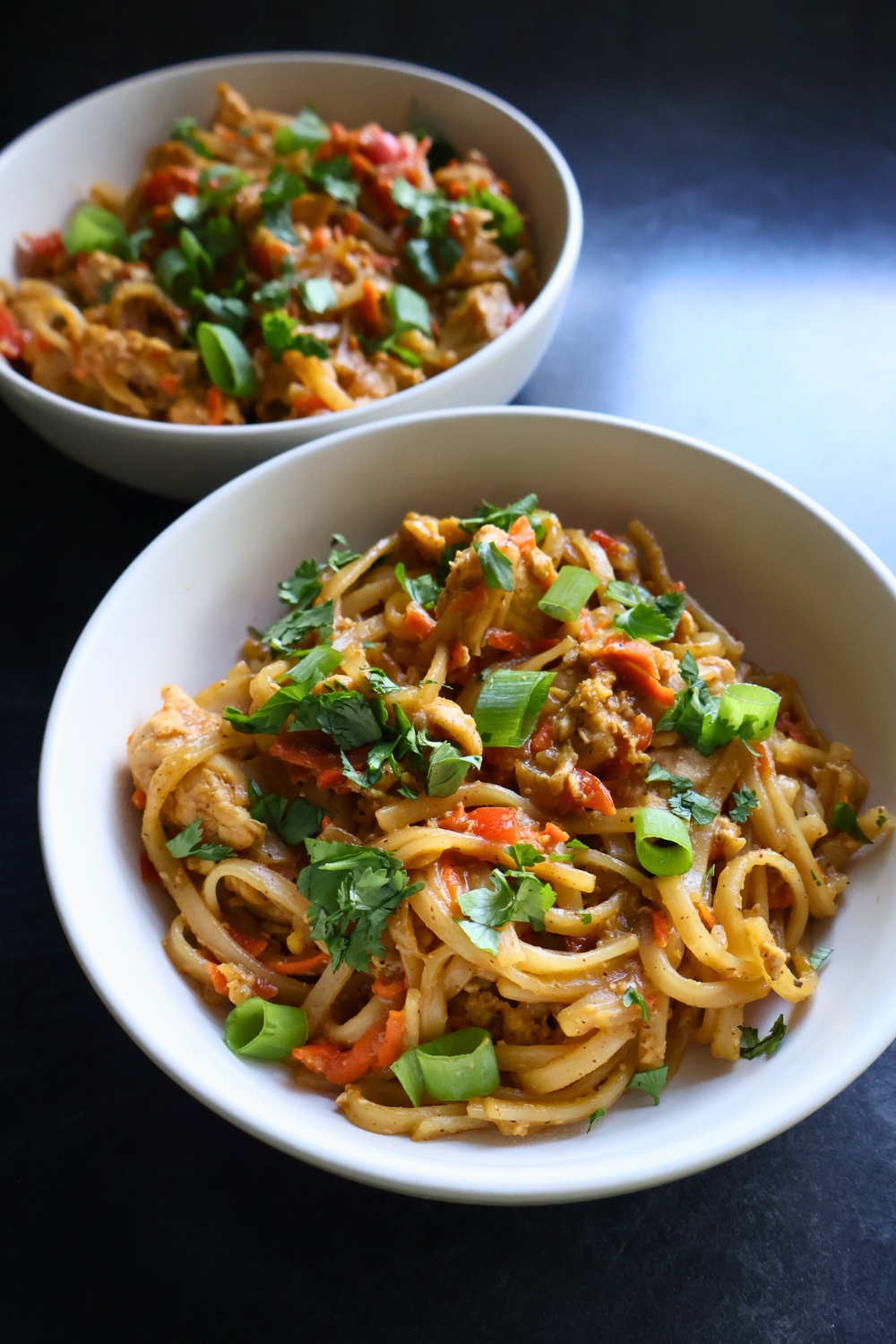 Gluten-free chicken pad Thai with cilantro and scallions sprinkled on top.