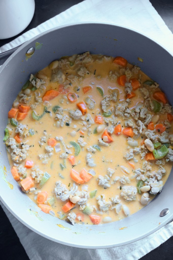 Close-up of gluten-free, dairy-free pumpkin chili with cannellini beans and celery.